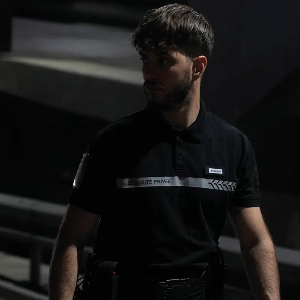 Man wearing black Polo Sécurité Privée by GK Safetek with reflective markings and grey stripe for enhanced visibility and functionality
